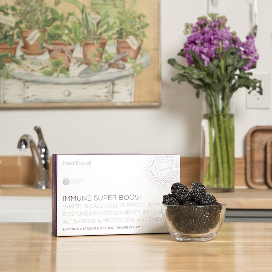 Healthycell Immune Super Boost box on a kitchen counter next to a bowl of blackberries
