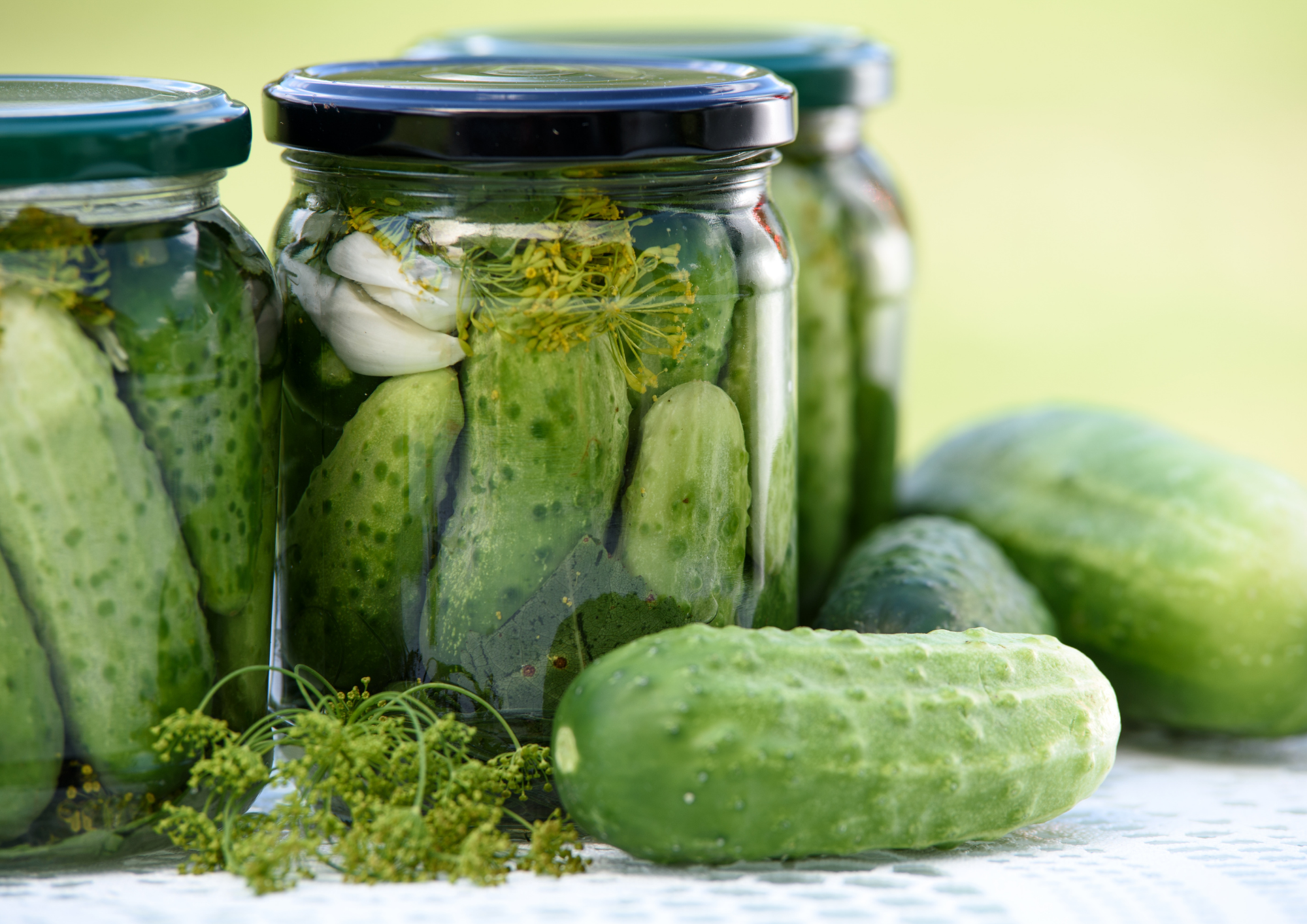 A jar of vinegar-pickled dill pickles with clear brine